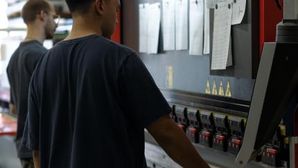 Zwei Personen arbeiten an einer Maschine