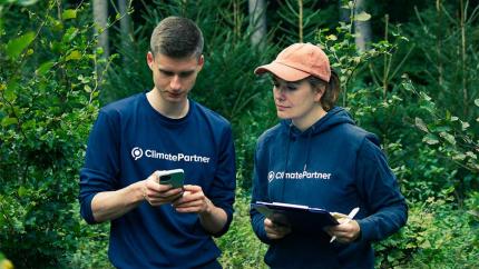 Two ClimatePartner employees in a lush forrest