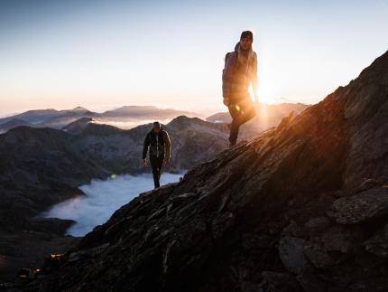 A man and a woman hiking up a mountain