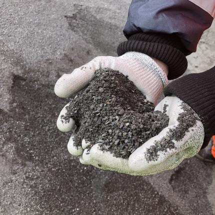 Hands holding crushed basalt rock