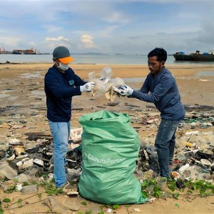 Menschen am Strand sammeln Plastik