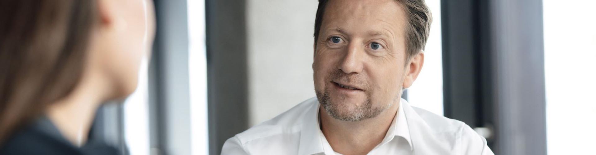 Moritz Lehmkuhl: Der Begriff "klimaneutral" als Auslaufmodell? Moritz Lehmkuhl, CEO von ClimatePartner, im Gespräch mit einer Frau