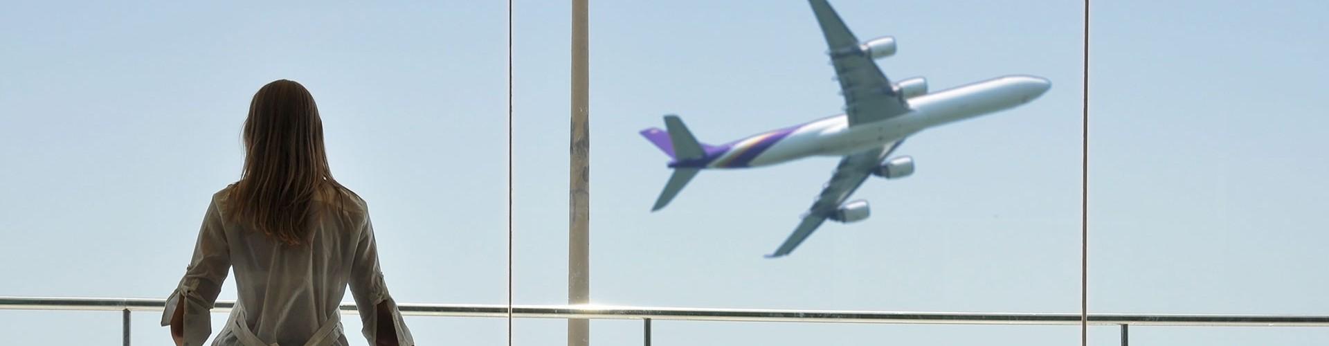 Nachhaltiger Flugverkehr? - CORSIA - Frau schaut auf startendes Flugzeug