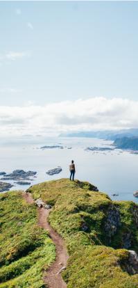 woman standing on rock watching sea