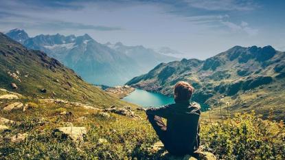 Man sitting in landscape in front of lake