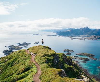 woman standing on rock watching sea