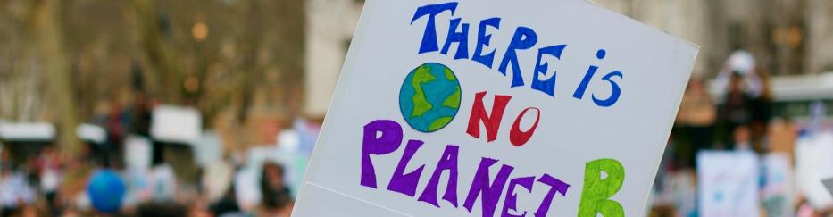 Demonstration by people, one of whom is holding up a sign reading ‘There is no planet B’.