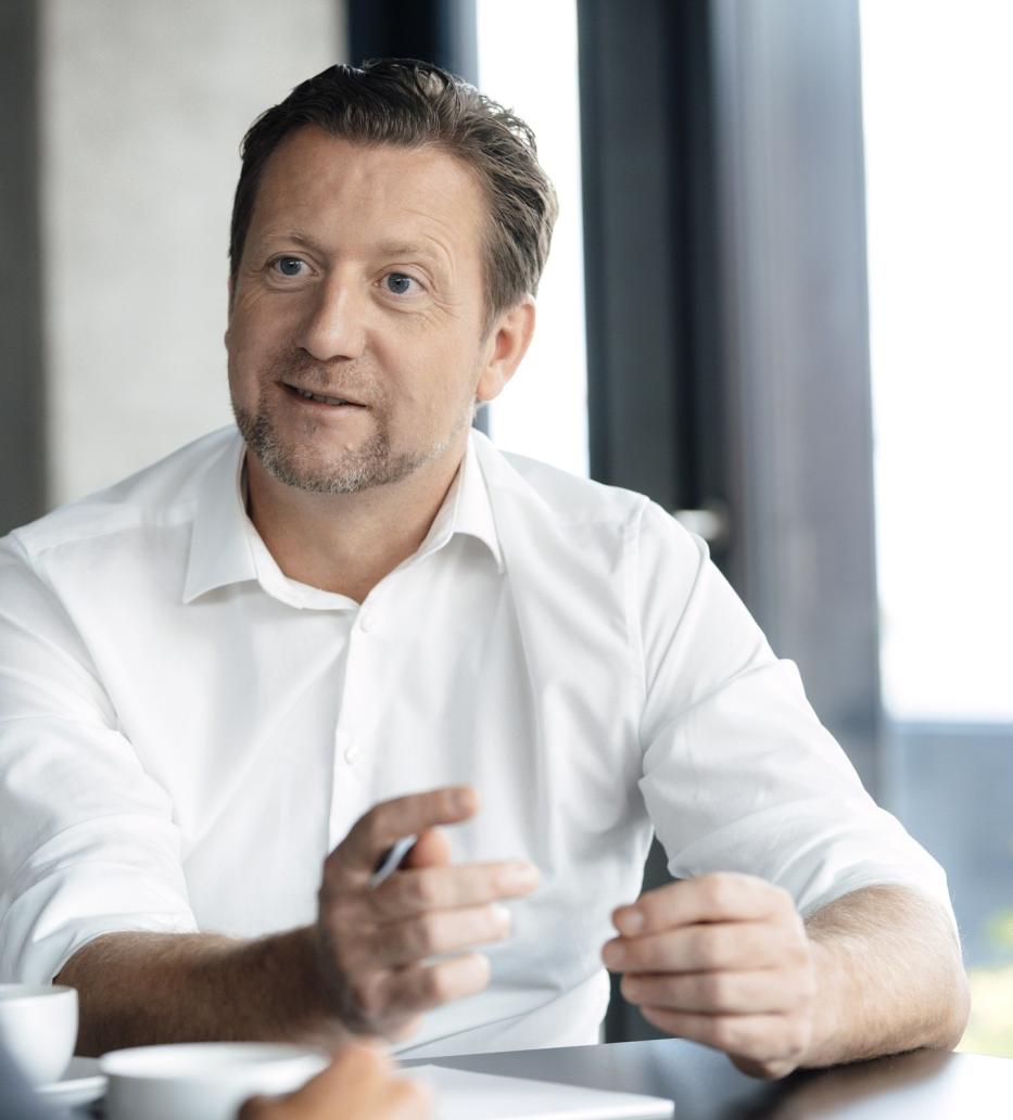 Mann sitzt am Tisch und unterhält sich